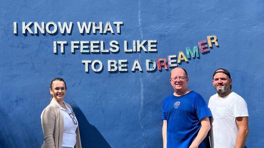 The team in front of Plastic Poetry 007 "I KNOW WHAT IT FEELS LIKE TO BE A DREAMER"