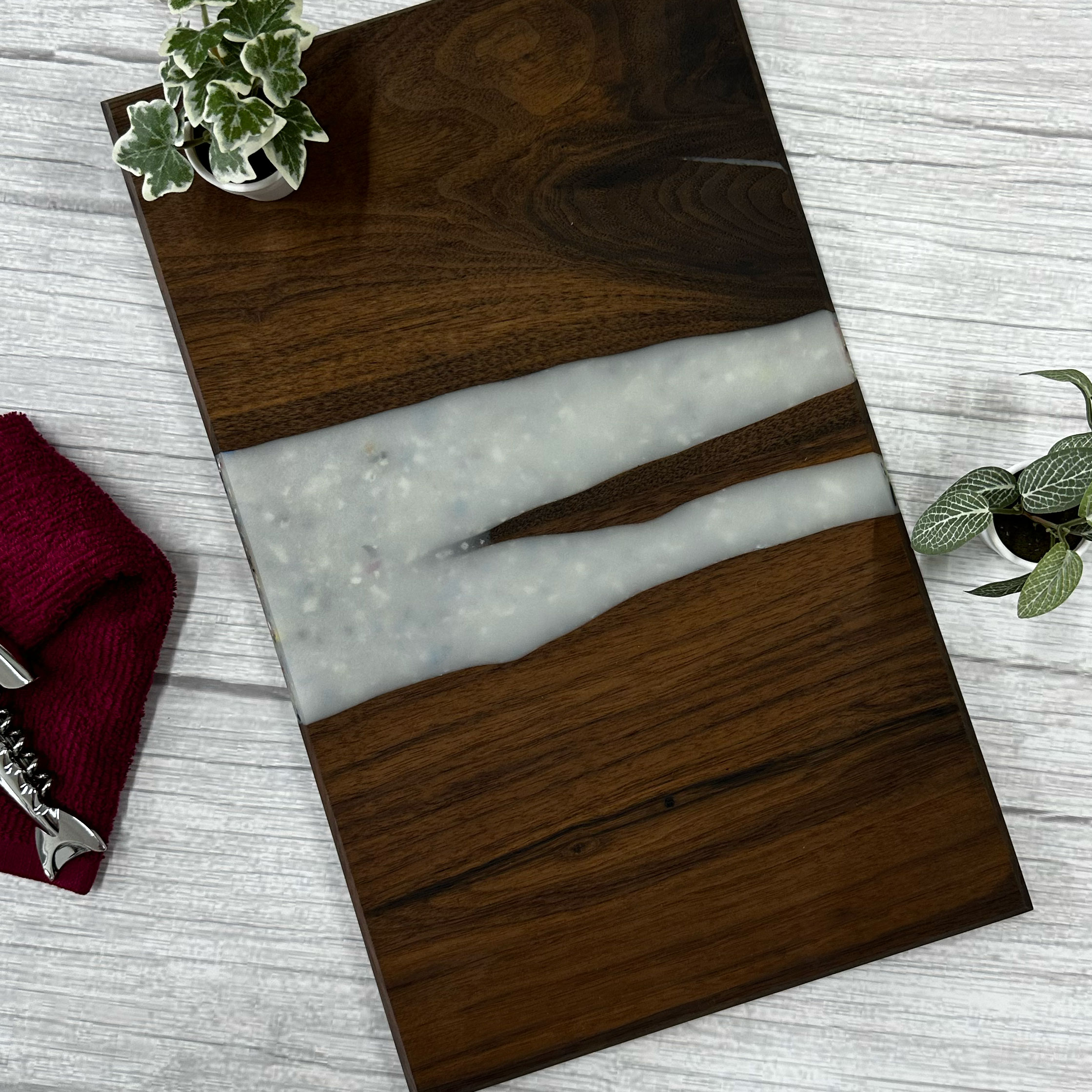 Walnut serving board with a white epoxy and plastic river